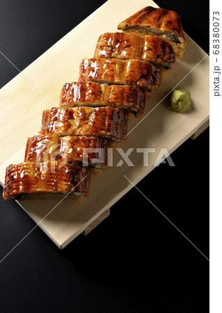 寿司下駄に盛り付けられた鰻の姿寿司とワサビ（黒背景、俯瞰） 68380073