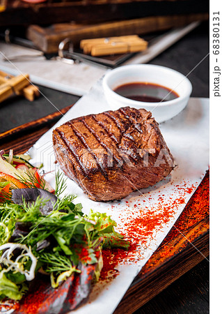 Fillet mignon steak on board with salad and sauce Fillet mignon steak on board with salad and sauce 68380131