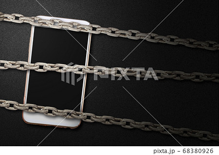 Chain fence locking smartphone on black background Chain fence locking smartphone on black background 68380926