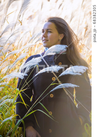 girl walks on nature among the reeds and shows her girl walks on nature among the reeds and shows her 68382305