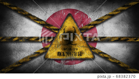 Coronavirus COVID-19 outbreak. Worn Yellow Biohazard, danger, warning sign over flag of Japan 68382370