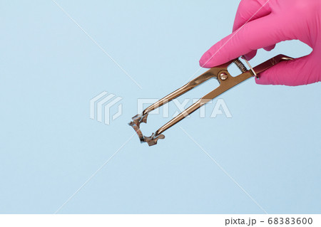 Dentist's hand in glove with dental tongs and Dentist's hand in glove with dental tongs and 68383600