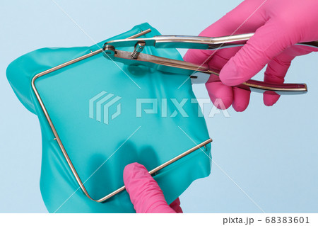 Dentist's hands in gloves with dental punch and Dentist's hands in gloves with dental punch and 68383601