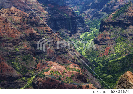 Elevated view of deep canyons, green fertile valleys and steep peaks of an island landscape Elevated view of deep canyons, green fertile valleys and steep peaks of an island landscape 68384626