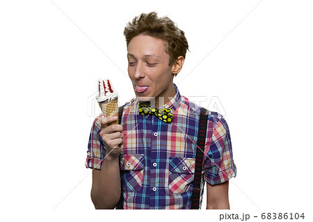 Happy teenage boy is eating ice-cream. Happy teenage boy is eating ice-cream. 68386104