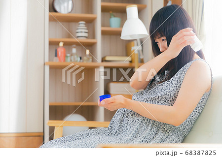 湿布スティックを患部にすり込む妊婦　肩　 68387825