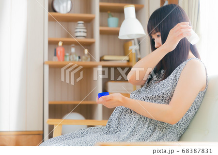 湿布スティックを患部にすり込む妊婦　肩　 68387831