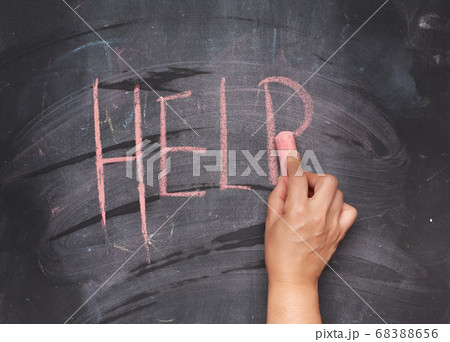 female hand with red chalk writes help on a black 68388656