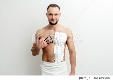 Young man shaving his chest Young man shaving his chest 68389566