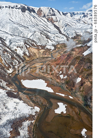 View of the Valley of Geysers, and Kronotsky nature reserve from a helicopter after a spring snowfall on the Kamchatka Peninsula View of the Valley of Geysers, and Kronotsky nature reserve from a helicopter after a spring snowfall on the Kamchatka Peninsula 68389576