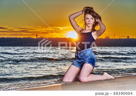 A young brunette girl in a black T-shirt and denim 68390004