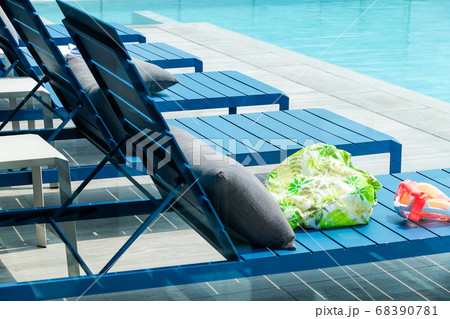 Swimming pool with chaise loungers background Swimming pool with chaise loungers background 68390781