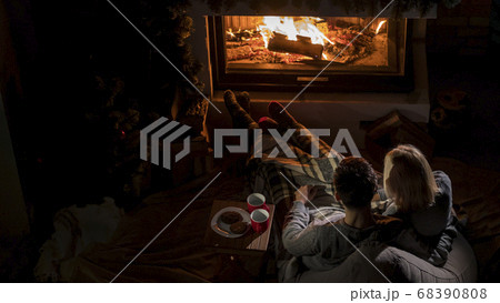 Young couple admires the fire in the fireplace, top view 68390808