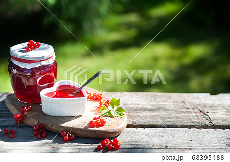 Red, juicy berries of red currants and jars of Red, juicy berries of red currants and jars of 68395488