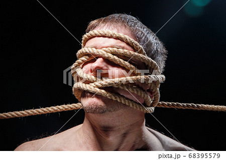 Image of binded scary man with rope on face 68395579