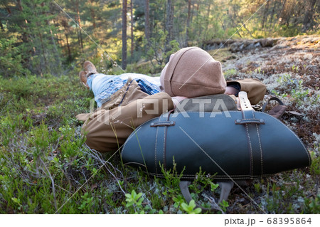 Man lies on the grass, resting at the forest relaxing Man lies on the grass, resting at the forest relaxing 68395864