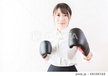 ボクシンググローブをつけてファイティングポーズをとるビジネスウーマンの写真素材 6965