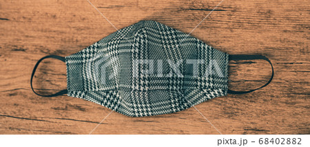 Fashion fabric face mask in plaid houndstooh pattern. Stylish masks for outfits during autumn winter with wooden panoramic banner background 68402882