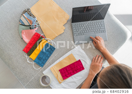 Online business woman working on computer laptop selling masks on website shipping fabric cloth mask worlwide. Top view of girl working from home 68402916