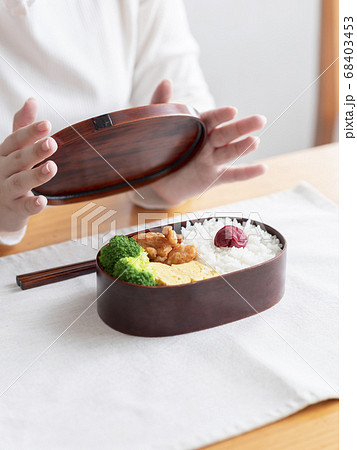 お弁当箱を開ける女性 68403453