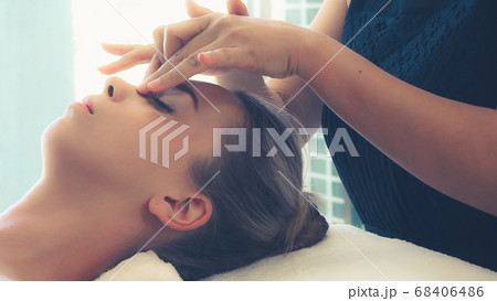 Woman gets facial and head massage in luxury spa. 68406486