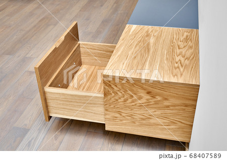 Floating media cabinet in contemporary living room. Wall mounted wooden cabinet with open drawers 68407589