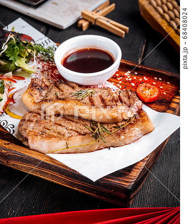 Grilled juicy steak sauce salad on wooden board 68408024