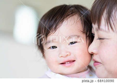 抱っこされている笑顔の赤ちゃんとお母さんのアップの写真素材 抱っこされている笑顔の赤ちゃんとお母さんのアップの写真素材