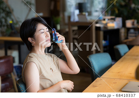 顔の汗をハンカチで拭く40代女性 顔の汗をハンカチで拭く40代女性 68410337