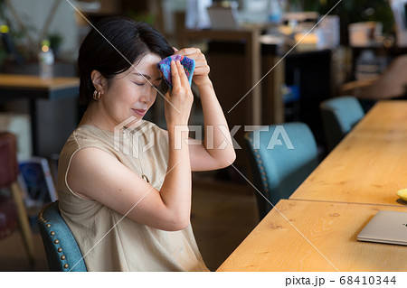 顔の汗をハンカチで拭く40代女性 顔の汗をハンカチで拭く40代女性 68410344