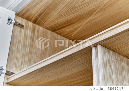 White wardrobe with wooden shelves close-up. Wooden filling of wardrobe 68412174