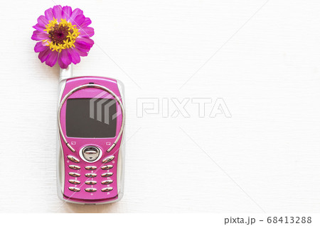 pink older little mobile phone press the button old generation with pink flower zinnia pink older little mobile phone press the button old generation with pink flower zinnia 68413288