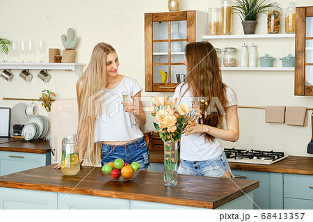 Two young pretty women drinking lemonade and Two young pretty women drinking lemonade and 68413357
