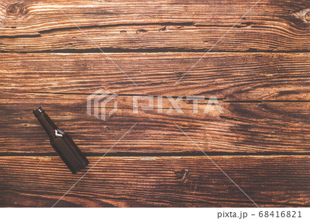 Flat lay of a beer bottle against a rustic wood Flat lay of a beer bottle against a rustic wood 68416821