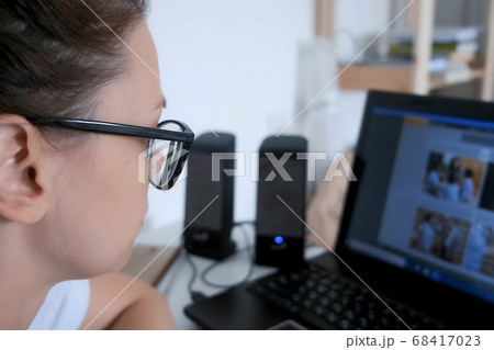 Portrait of woman student learning language on computer sitting at home in dark. 68417023