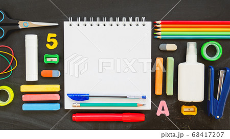 Top view on colorful stationery. Back to school flat lay concept. Horizontal 16:9 blackboard background with copy space on notepad. 68417207