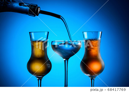 Strong alcoholic drink is poured from the bottle 68417769