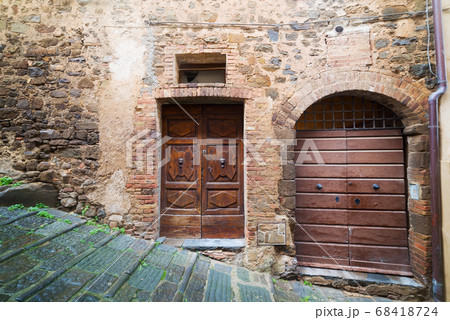 wooden doors in a rustic wall in Montalcino 68418724