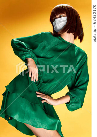 Woman in fashion dress posing in medical mask virus covid-19 Woman in fashion dress posing in medical mask virus covid-19 68420170