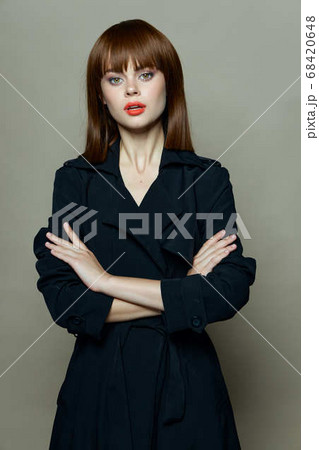 woman in a black coat crossed her arms over her chest 68420648