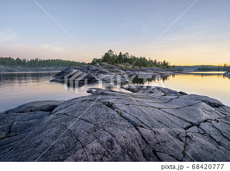 Beautiful sunrise on a rocky shore. Mixed forest Beautiful sunrise on a rocky shore. Mixed forest 68420777
