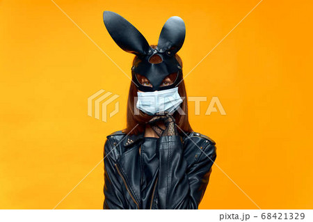 Female rabbit mask posing sexually in a medical mask from coronavirus 68421329
