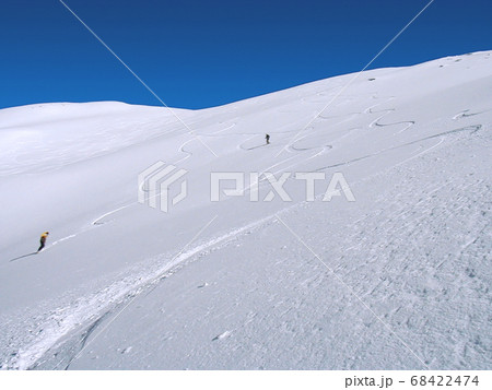 快晴の雪山に広がる新雪のパウダースノーにシュプールを描く 68422474