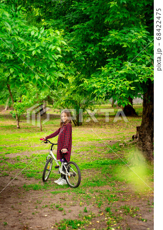 girl with Bicycle in spring Park.  68422475