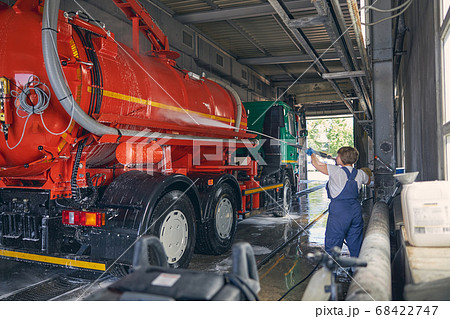 Attentive brunette female person cleaning orange barrel Attentive brunette female person cleaning orange barrel 68422747