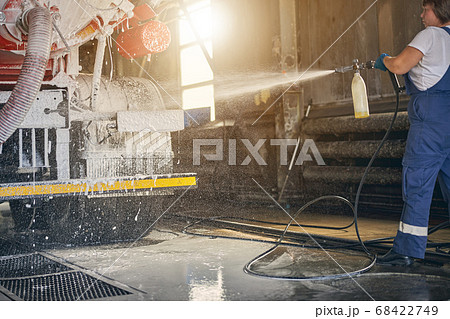 Attentive brunette woman looking at foam on headlight Attentive brunette woman looking at foam on headlight 68422749