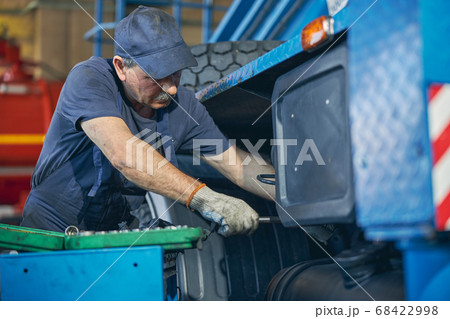 Concentrated mature man doing checkup of breakage Concentrated mature man doing checkup of breakage 68422998