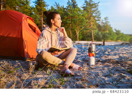 Charming female traveler reading book on the beach 68423110