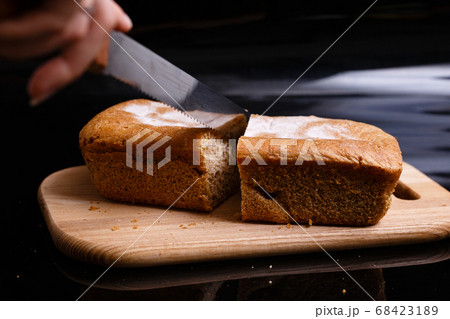Homemade gray bread on a black background. Photo in section. Homemade gray bread on a black background. Photo in section. 68423189