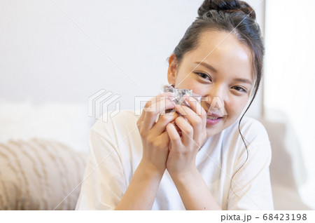 自宅できんつばを食べる若い女性 68423198
